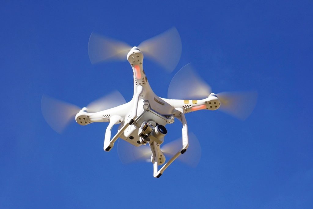 Drohne im Flug vor blauem Himmel, kurz vor der Fassadenbefliegung