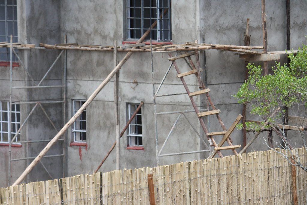 Gerüst und Leitern an einer Hausfassade während Sanierungsarbeiten